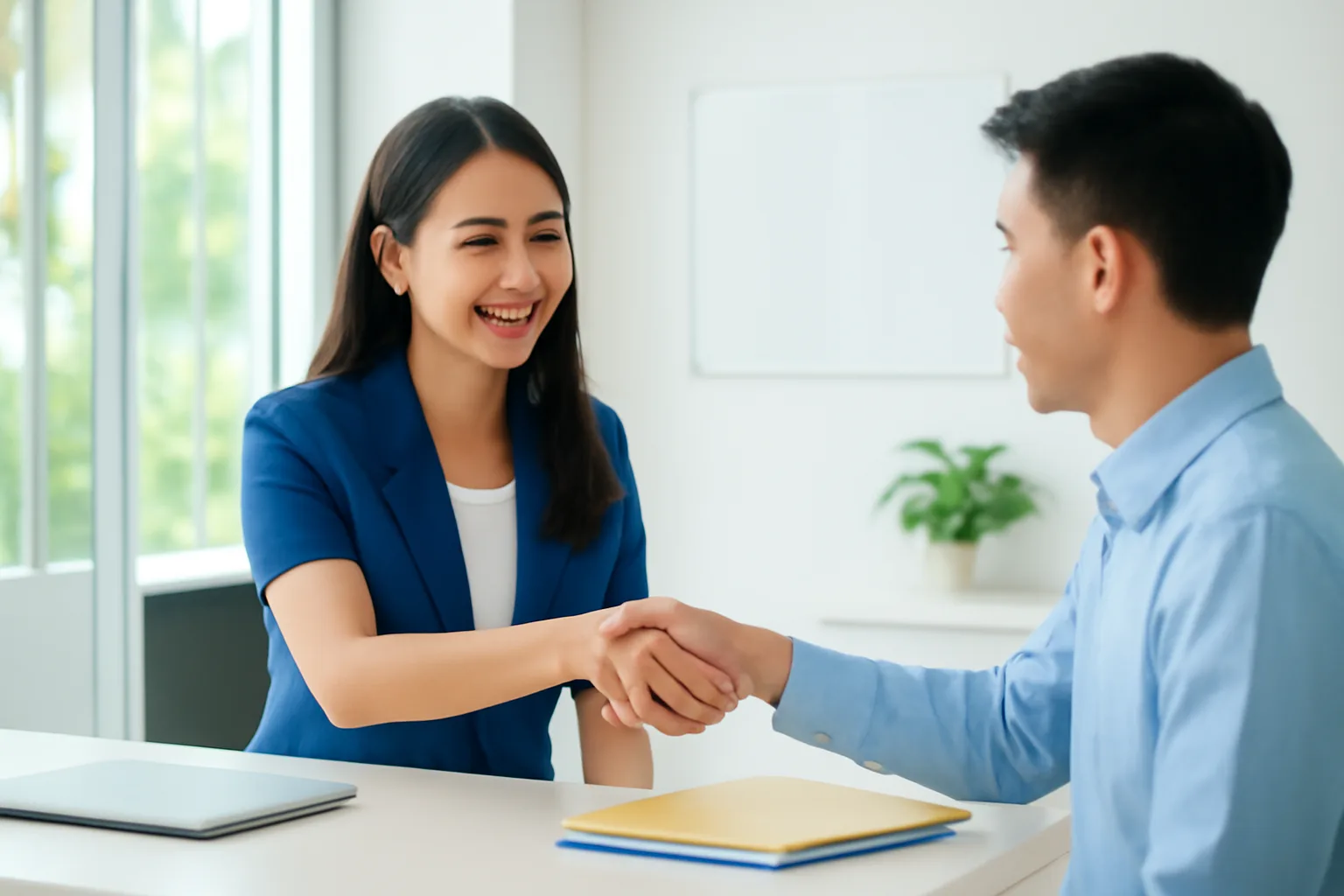 Cán bộ nhân sự bắt tay nhân viên mới ở quầy lễ tân sáng sủa